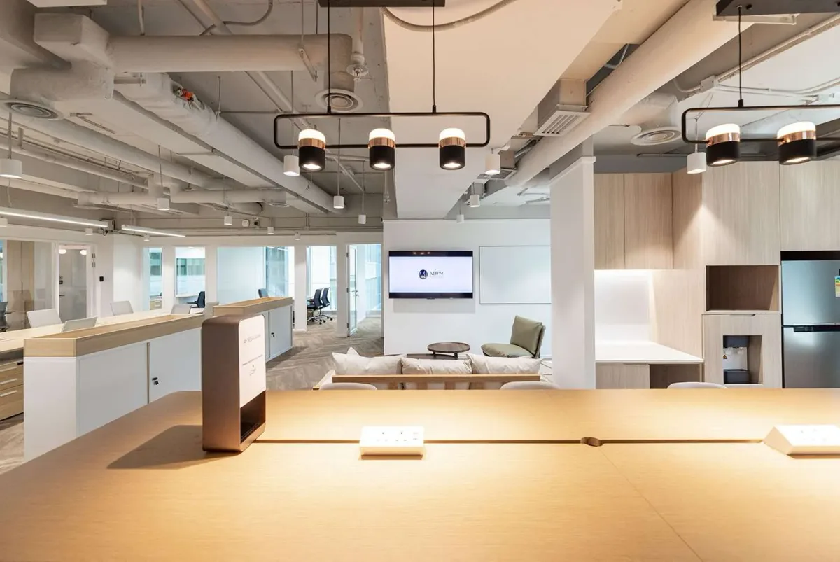 Completed office reception with layered lighting, client seating and integrated joinery
