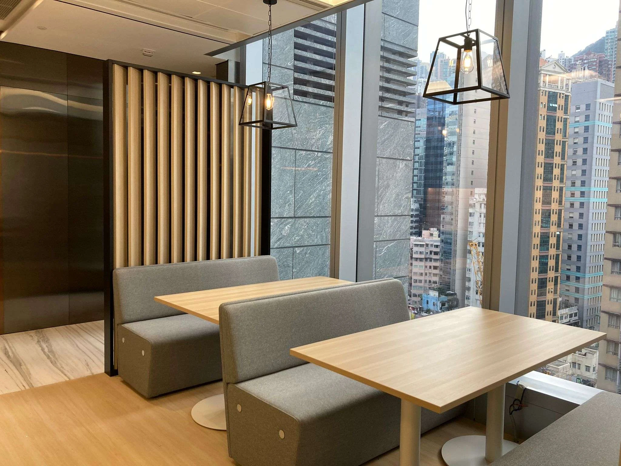 MJPM-designed breakout area with workplace booths, timber finishes and Hong Kong city views
