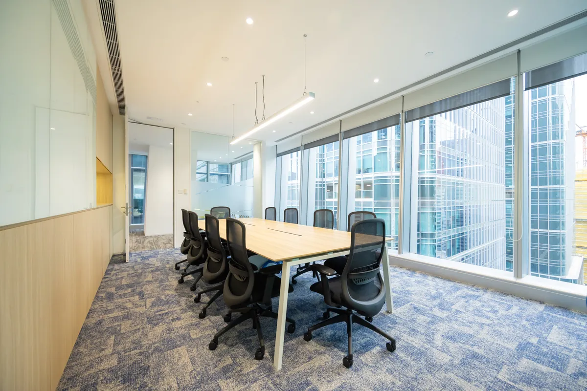 Meeting room with floor-to-ceiling windows overlooking Hong Kong office towers