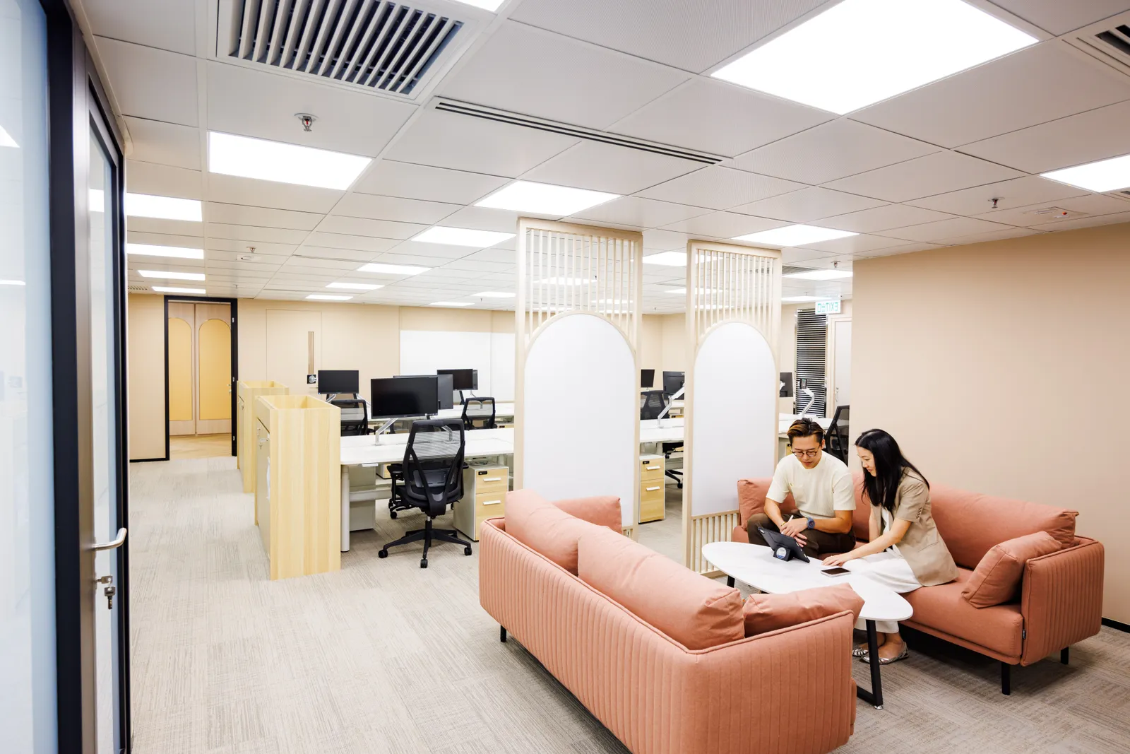 MJPM team members reviewing plans in a lounge area of an open-plan office