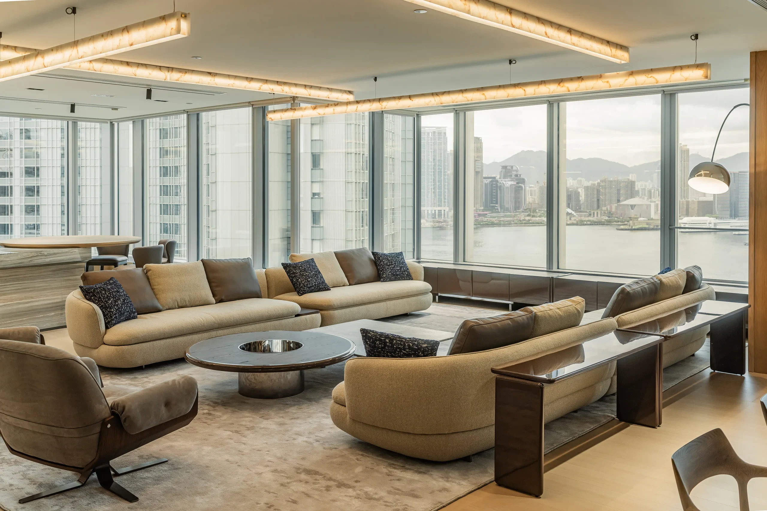 Completed workplace lounge with seating, architectural lighting and Hong Kong skyline views